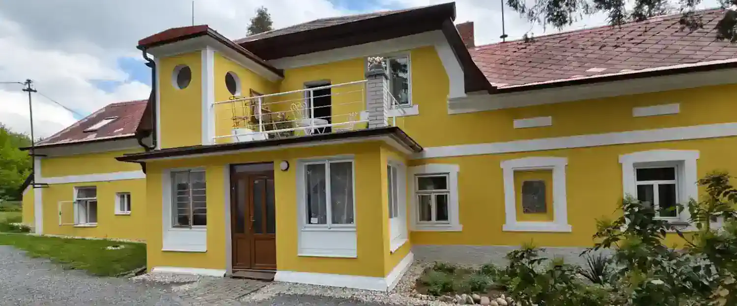 Žlutý dům Josefa Suka v Křečovicích, obklopený stromy a zahradou